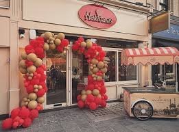 The Haldiram&rsquo;s London shopfront on opening day, framed by a red and gold balloon arch