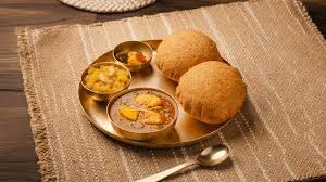 A Haldiram&rsquo;s thali of chole bhature served on a brass plate