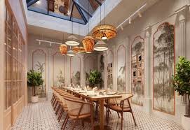 A STEM Hospitality dining room with a long communal table, rattan pendant lights and a glazed roof